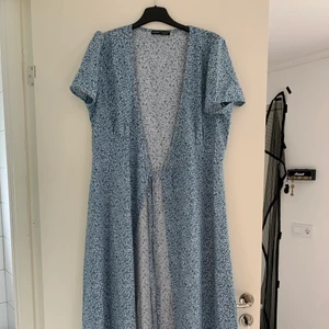 Blommig klänning - Aldrig använd och andra bilden visar hur den ska sitta.