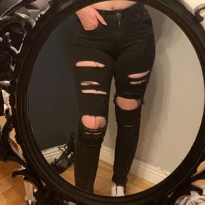 Svarta högmidjade jeans storlek S - Svarta håliga jeans ifrån H&M. Använda men i ett bra skick. Storlek S men kan också passa en XS. Högmidjade.  