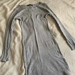 Grå ribbad klänning - Grå långärmad ribbad klänning i viscose. 