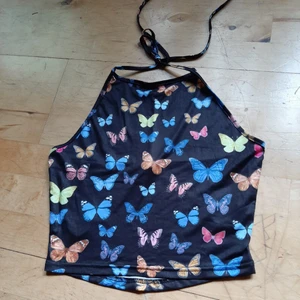 Halternecklinne med fjärilar!  - Säljer ett fint och populärt halternecklinne i storlek S! Kan även passa XS. Oanvänt, säljes då det inte passade. Säljes för inköpspris 50 kr + 22 kr i frakt 🦋