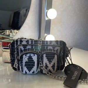NUNOO väska⚡️ - Cool väska från Nunoo i nyskick, lappen sitter kvar! Säljer pga att jag ej fått någon användning för den. Köptes för 1369kr! Två axelremmar medföljer. Bredd: 18 cm Höjd: 10 cm Djup: 4 cm⚡️