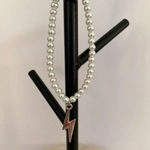 Vitt pärlarmband med silvrig blixtberlock  - Vitt pärlarmband med silvrig blixtberlock⚡️  Pris: 39kr/st   Fraktkostnad på 12kr tillkommer.