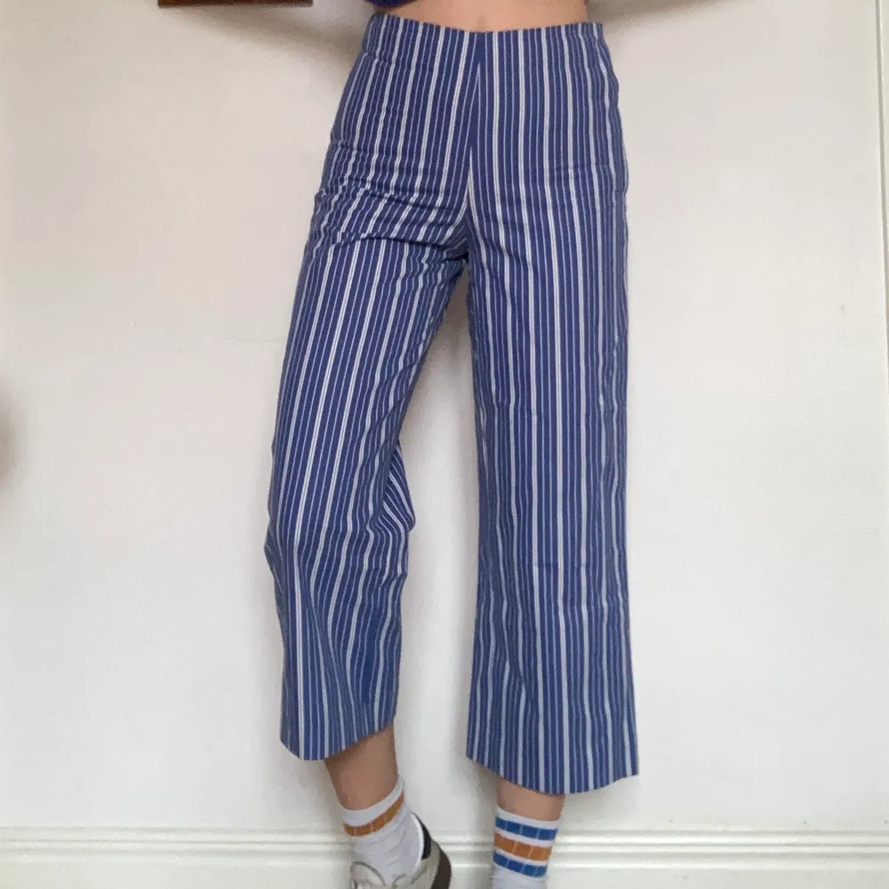 Jättefina cropped blå-vitrandiga byxor från Zara ca 2016. Dom har använts ett fåtal gånger då jag är lite för lång för dom. Min längd är 179cm så dom kanske inte sitter lika cropped på dig som är kortare!. Jeans & Byxor.