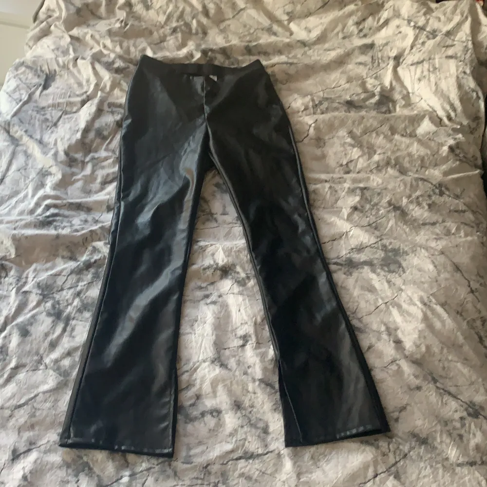 Det är ett par svarta skinbyxor med slits längst ner storlek 40 och är från h&m!. Jeans & Byxor.