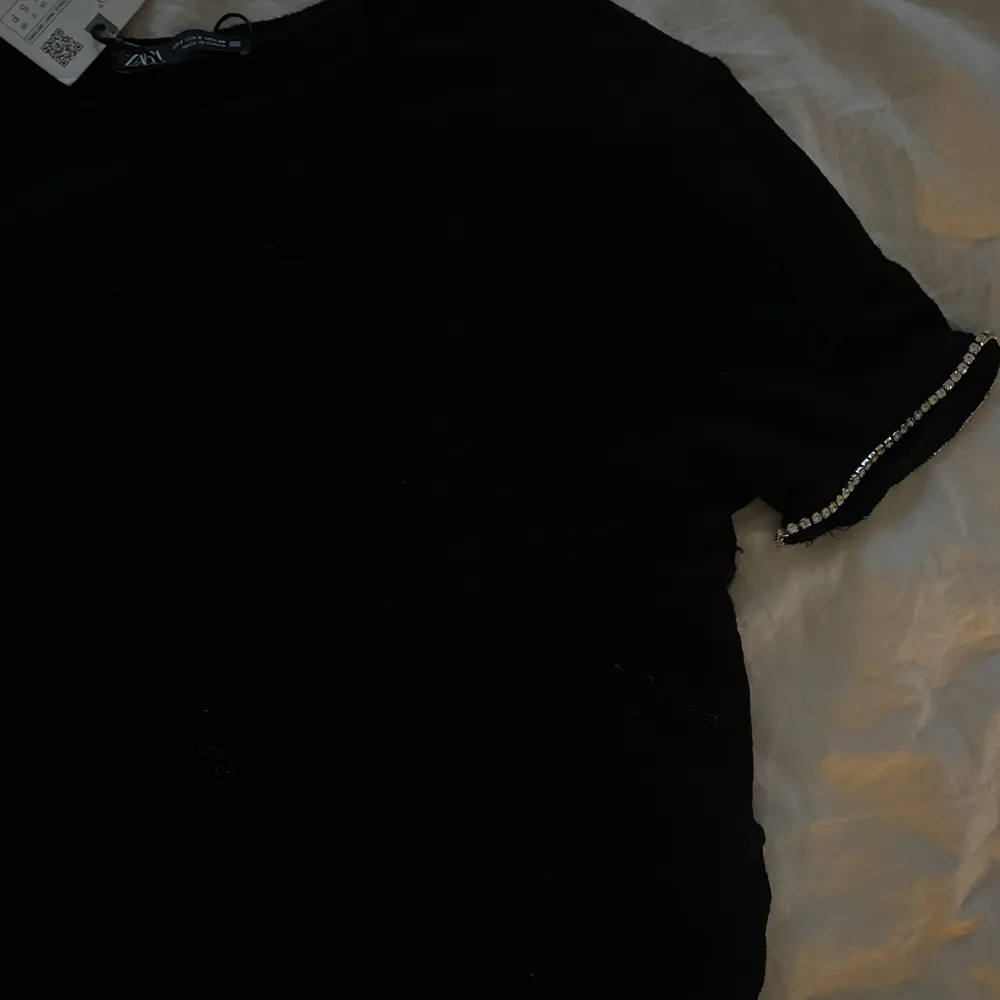 fin svart stickad t-shirt, helt ny med prislapp stl S men passar också xs, fina paljett detaljer på ärmarna<33. T-shirts.