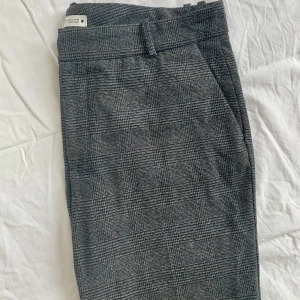 Nya slacks från Zara/ stl: 44 - Slacks från Zara i storlek 44, men passar även 42. Helt nya, säljes då de inte passar mig i storleken. Avsmalnande modell med dragkedja i gylfen och hake samt knapp. Normalhög midja och bälteshållare. Två fickor fram. Fin grå färg i slitstarkt material.