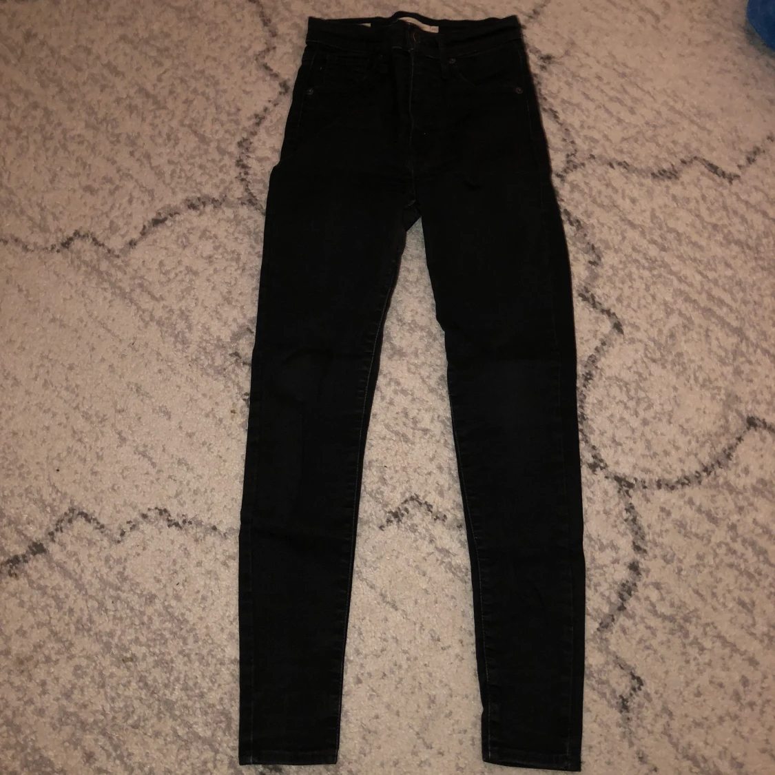 Svarta högmidjade Levi’s jeans.