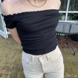 Gina Tricot Svart offshoulder topp - Svart offshoulder topp från Gina Tricot i ribbat material med vågiga kanter! Aldrig använd så i väldigt gott skick! Den är i storlek s men är ganska liten i storleken så skulle beskrivs den mer som XS, det ribbade materialet gör dock att den blir väldigt stretchig! Nypris 129kr, mitt pris 65kr inkl. frakt!