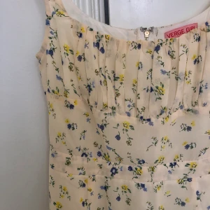 Verge Girl klänning  - Blommig pastell-gul klänning från den australiensiska hemsidan Verge Girl. Använd men i fint skick. Säljer den då den är för stor för mig i bysten (jag har 70A i bh) frakt är inkluderat i priset.
