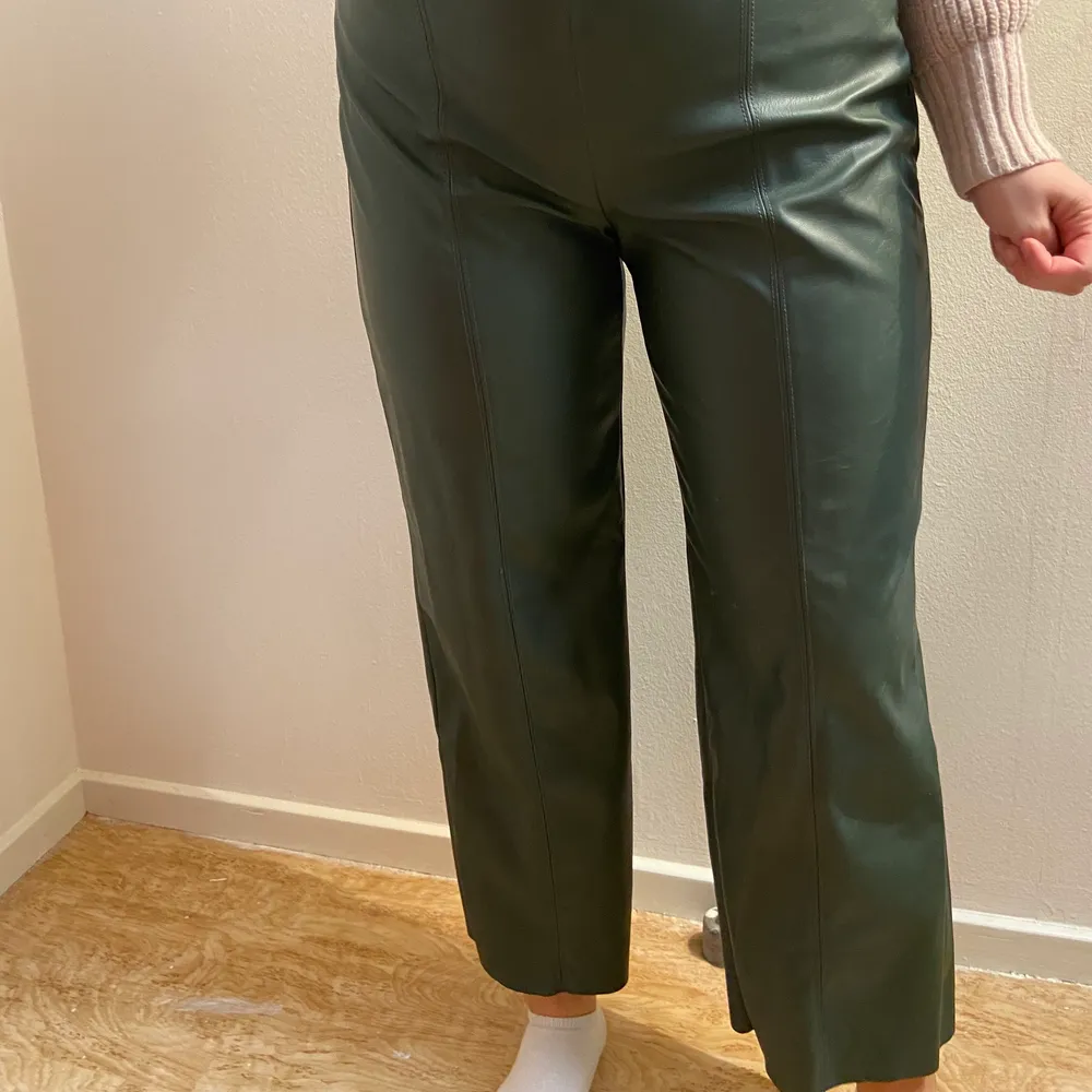 Stilrena mörkgröna läderbyxor (läderimitation) i fint skick, endast använda 1 gång!! Dragkedjan på sidan. . Jeans & Byxor.