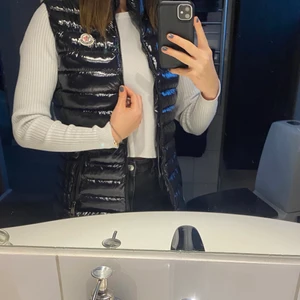 Moncler väst - Moncler väst dock osäker på om den är äkta där av priset. Den är i storlek 2 och nyskick! Passar mig som har storlek S och kan använda en hoddie under.