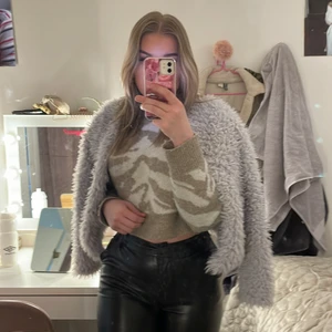  Jacka  - De är en fluffig jacka från ginatricot som också är grå 