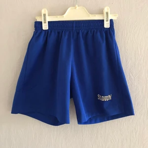 Stadium  - Blå träningsshorts. Passar både killar och tjejer. Storlek 134/140 men passar mig som har storlek XS i vanliga fall. 