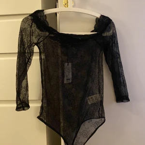 Spets body - En jättefin off shoulder spets body från bikbok. Aldrig använd prislappen kvar! Den har en fin spets kant upptill och silokon runt om för att hålla den på plats! Det står att den är M men skulle säga mer som en S