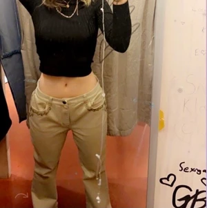 Baggy lågmidjade byxor - Baggy lågmidjade bootcutliknande byxor från beyond retro med guldiga detaljer på sidorna. Knappt använda sen jag köpte dom i december. För långa för mig på mina 163 cm så behövdes vikas upp, vilket funkade bra. Vid intresse skriv till mig.