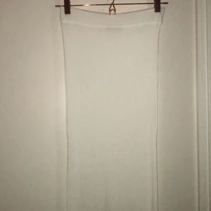 Vit stickad kjol från Ginatricot - Jätte fin kjol i superbra skick. Alldrig använd då den är i fel storlek. Storlek XS. Kjolen är lång och går nedanför knäna. Vit ribsbtickad kjol. Köparen står för frakten.