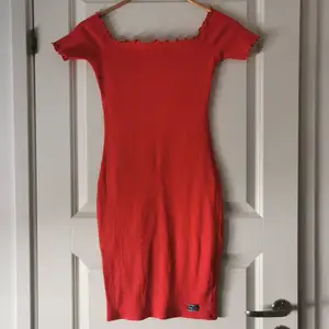 Tajt klänning i koral/hallonröd färg. Endast använd en gång 