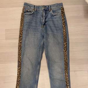 Ett par blåa jeans från gina tricot som inte kommer till användning då de är för små. Ränder med leopardmönster på båda sidorna. Rak modell