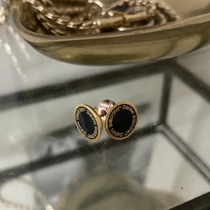 Marc Jacobs örhängen - Svart-guldiga örhängen från Marc Jacobs. Köpta för ca 600kr. Eftersom örhängena är använda en gång är de i topp skick! Säljer för ett lågt pris då det var längesedan de köptes. OBS! Noggrant rengjorda!! Högsta bud: 170kr🤩