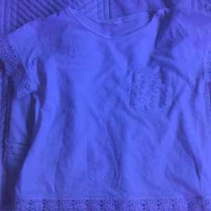 Vit t-shirt. Stl. 134/140 - Vit t-shirt från Kappahl. Har lite volanger på sig.