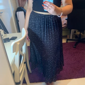 Plisserad kjol - Jättesöt svart plisserad kjol med vita prickar på. Perfekt till sommaren🦋 har aldrig använts och har prislappen kvar, passar M/L