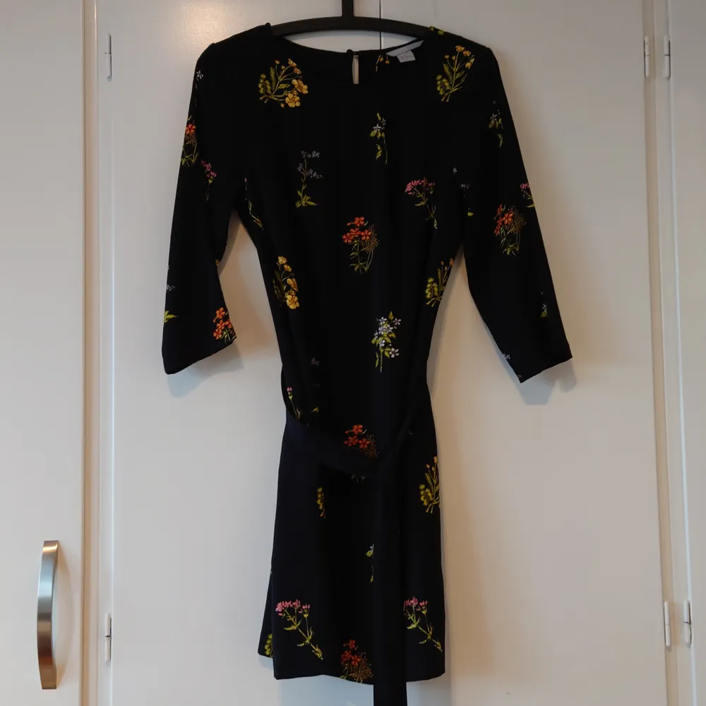 H&M svart blommig klänning, strl 38. Använd en gång, mycket fint skick! Köparen står för frakt. (Kan skickas som brev då blir frakten billigare, men då är det ej spårbart). Klänningar.