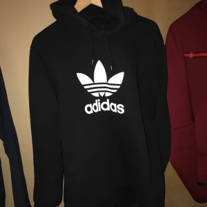 Adidas  - Adidas svart hoodie, de håller dig varm som har två fickor på sidan, sköna varma material, brukar ej finnas därute.  Köptes från Adidas butiken, Original priset 1200