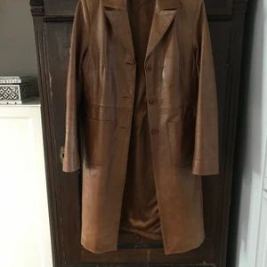 Brun Skinnjacka från AUS - Intressekoll på denna bruna, fina, trendiga skinnjacka som går till knäna på mig som är 172cm. Köpt i Australien. Väldigt fint skick. Om den är poppis så kör vi budgivning! 🥰 