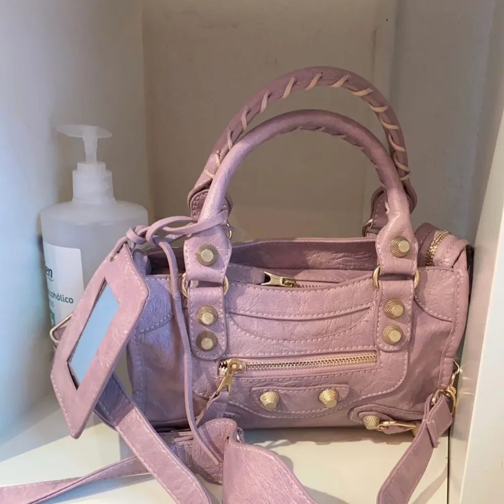 Balenciaga väska i bra skick. Använd ca 10 gånger. Lila/rosa färg som på bilden där den står i ett skåp. Köpt för 16 000 kr. Väskor.