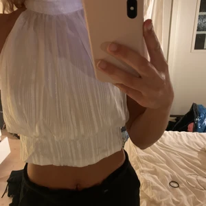 Vit topp - En elfenbensfärgad topp från Asos, aldrig använd. Knyte därbak och ränder i metallic. Storlek 38. Nypris 256kr 