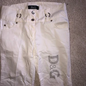 Byxor Dolce&Gabanna - Ett par vita byxor från D&G köpta på second hand. De är bootcut modell och är i jättebra skick!