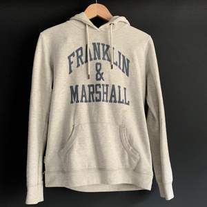 Enkel grå hoodie med tryck från Franklin & Marshall. Den är använd men fortfarande i fint skick. Stl s. Köparen står för frakt.
