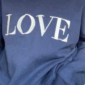 Blå hoodie med text ”Love” 