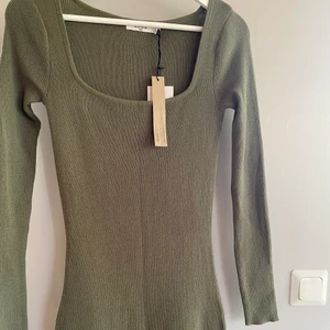 Grön figursydd långklänning från Na-Kd, storlek 36 - Jättefin långklänning från Na-Kd, slits vid ena benet. Figursydd och väldigt mjukt material, går ner till fötterna på mig som är 168cm lång. Storlek 36, helt oanvänd, lappar kvar.