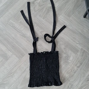 Smockad kort topp  - Kort snygg topp med knytband, passar bra till höga kjolar eller för dig som gillar att visa magen :) 