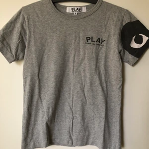 CDG Play / Comme Des Garçons Grey Tee - CDG Play / Comme Des Garçons Grey T-Shirt  Size small, fits like a regular size small.  Excellent condition, no flaws or damage.  DM if you need exact size measurements.   Buyer pays for all shipping costs. All items sent with tracking number.   No swaps, no trades, no offers. 