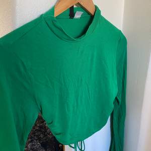En snygg tröja i en fin grön färg med öppen rygg som man knyter.  