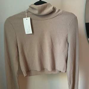 Croppad beige polo - Helt ny, aldrig tvättad , lappar kvar. Stl M är som S 
