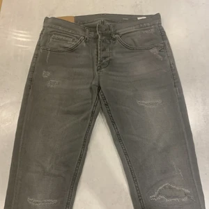 Dondup George Jeans Slim Grey - Dondup jeans i storlek 32, gråa med lätt slitning på jeansen. Väldigt bra kvalité och inga synliga tecken på användning. Jeansen är low waist