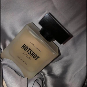 Hotshot But Hotter Linn Ahlborg  - Linn Ahlborg x Nordicfeel. Helt slutsåld!   Hotshot But Hotter är en varm och stilren doft samtidigt som den är elegant och exklusiv på personen som bär den. De lekfulla toppnoterna av svartvinbär, bergamott och mandarin kombineras perfekt ihop med noter från hallon, neroli och jasmin. I basen finns vanilj och mysk som ger doften dess eleganta ton. 50ml. FLER INTRESSEAD BUD!