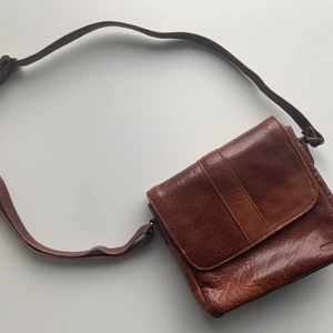 Axelremsväska  - Väskan är i äkta läder och har knappt använts, fint skick! Måtten ligger på ca 20x20x6 (cm). 