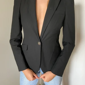 Svart kavaj, Zara. Axeldetalj. - Figursydd svart kavaj från Zara. Silvriga knappar och puffärmar. Fint skick.