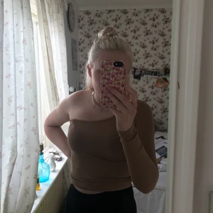 Beige one shoulder tröja - Säljer denna super snygga tröja, skriv privat för mer bilder om de önskas. Fint skick bara testad, stl xs men är super stretchigt material. Köpare står för frakten🤎 vid fler intresserade blir de budgivning.