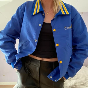 Collegejacka  - INTRESSEKOLL! Vintage collegejacka i en konblå färg med gult tryck på baksidan! Köpt på Beyond retro & endast använd ett fåtal gånger. Snyggt oversized i storleken. 😁💙 