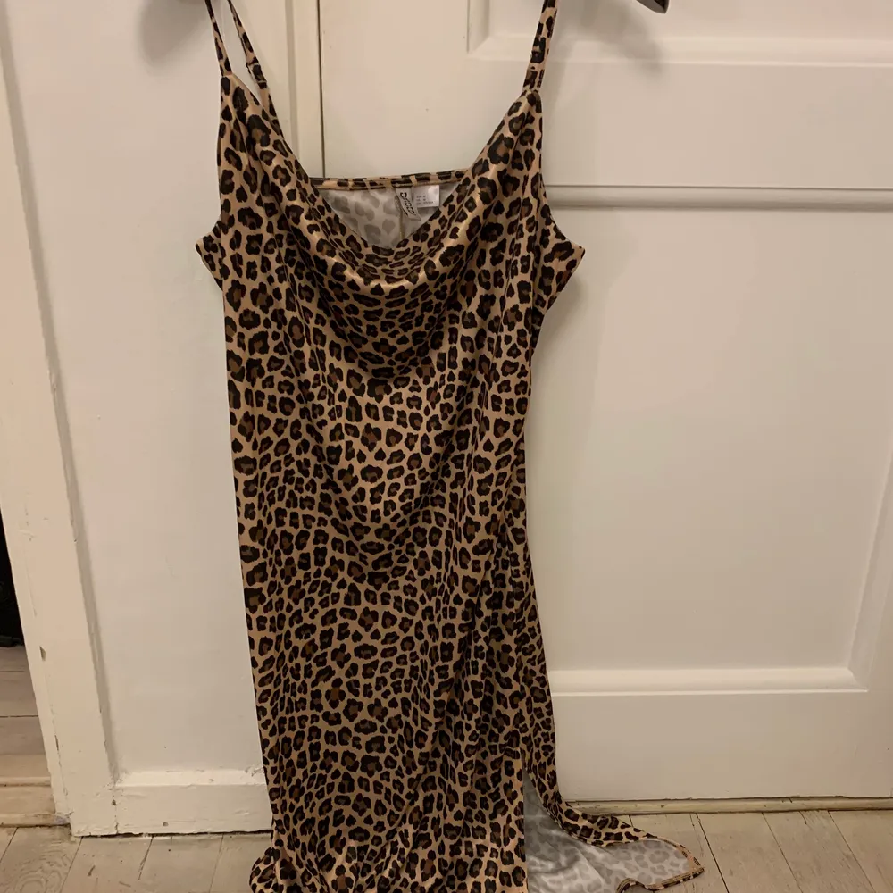 Snygg leopard klänning i glansigt material och liten slitts. Klänningar.