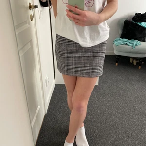 Rutig kjol - En rutig tight kjol med lite rosa detaljer. Stretchig. Använd Max 5 ggr. 