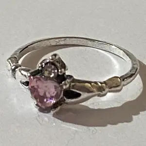 Silverring med en rosa kristall och små detaljer.
