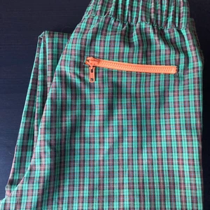 Collusion byxa - Skitcoola grön/brun rutiga byxor i lite kortare modell med orange dragkedja som detalj. Använda sparsamt så typ i nyskick! Tyvärr lite för stora för mig. 