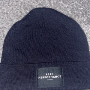 Mössa, peakperformance  - Säljer denna mössa från peakperformance, endast testad då färgen inte var något för mig, (mörkblå). Annars jätte skön.                     Nypris: 399kr                                                      Mitt pris: 199kr                                                  Skriv för mer bilder osv🥰, är öppen för prutning😊
