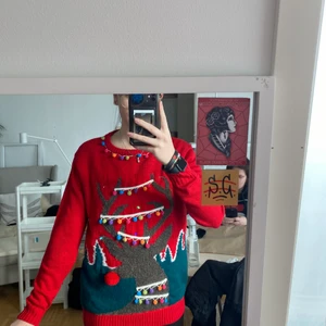 Jultröja med ljusslinga i S - En röd jultröja med en inbyggd ljusslinga i olika färger. Använd två gånger på julafton. Nyskick, och materialet är stickat typ. 50kr + frakt